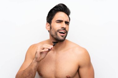 İzole beyaz duvarın üzerinde sakalını tıraş etmiş bir adam