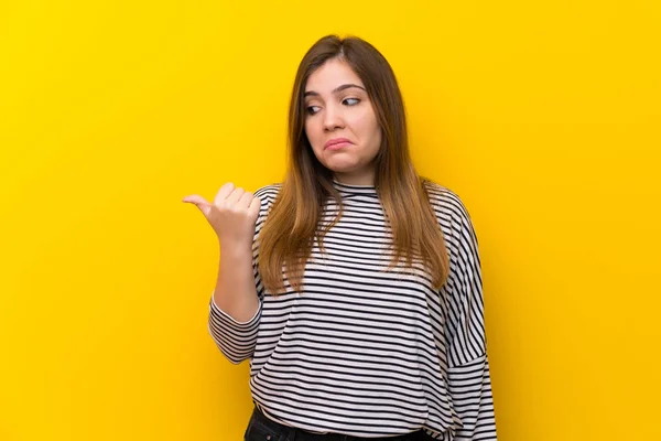 Sarı Duvar Üzerinde Genç Kız Mutsuz Yan Işaret — Stok fotoğraf