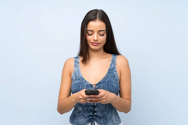 Giovane Donna Oltre Isolato Muro Blu Utilizzando Telefono Cellulare — Foto Stock