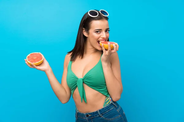 Mujer joven en traje de baño en vacaciones de verano con pomelo —  Fotos de Stock