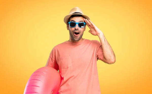 彼の夏休みに帽子とサングラスを持つ男はちょうど何かを実現し オレンジ色の背景に解決策を意図している — ストック写真