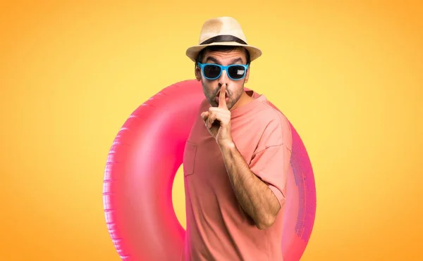 夏休みに帽子とサングラスをかけた男は オレンジ色の背景に口に指を入れて口を閉じる兆候と沈黙のジェスチャーを示す — ストック写真