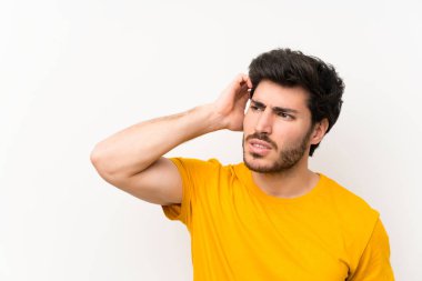 Şüpheleri olan izole beyaz duvar üzerinde Yakışıklı ve yüz ifadesi karıştırmayın