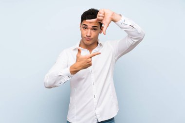 Mavi duvara odaklanmış, yüzü olan yakışıklı bir adam. Çerçeveleme simgesi