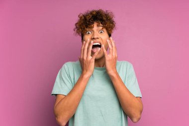 Sürpriz yüz ifadesi ile izole mor duvar üzerinde genç afro-amerikan adam