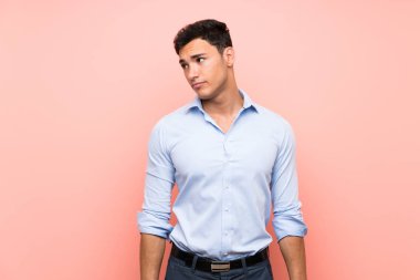 Pembe arka plan üzerinde Yakışıklı adam yan görünümlü şüpheler jest yapma