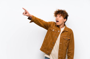 Izole beyaz duvar üzerinde genç afro-amerikan adam uzağa işaret