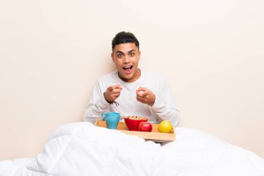 Yatakta kahvaltı olan genç adam seni parmak