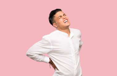 Renkli arka plan üzerinde bir çaba için sırt ağrısı muzdarip genç adam