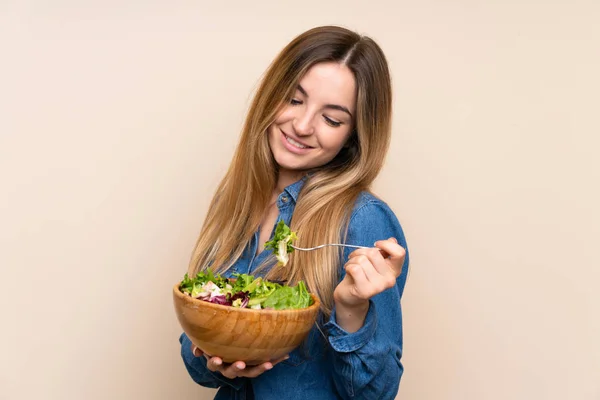 Young woman with salad over isolated background