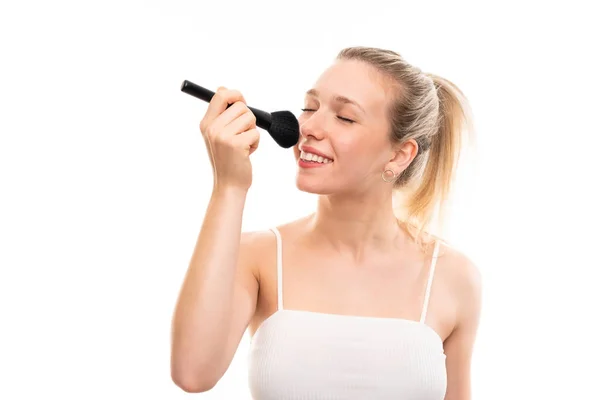 Jonge blonde vrouw over geïsoleerde witte achtergrond met make-up br — Stockfoto