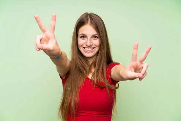 Mladá Žena Dlouhými Vlasy Izolované Zelené Stěně Usmívající Zobrazující Vítězné — Stock fotografie