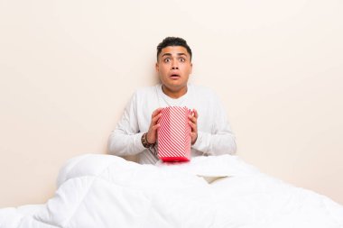 Patlamış mısırile yatakta genç adam