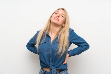 Bir çaba yapmış olduğu için sırt ağrısı muzdarip izole beyaz duvar üzerinde genç sarışın kadın