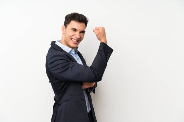 Izole beyaz duvar üzerinde yakışıklı adam güçlü jest yapıyor