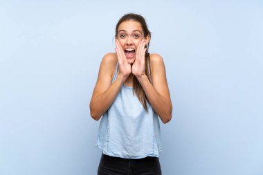 İzole mavi arka plan üzerinde genç kadın çığlık ve bir şey duyurdu