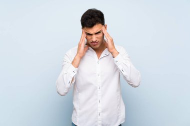 Baş ağrısı ile mavi duvar üzerinde Yakışıklı adam