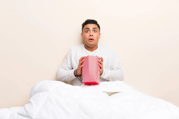 Jeune homme au lit avec des popcorns — Photo