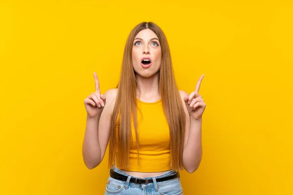 Mujer Joven Sobre Fondo Amarillo Aislado Señalando Con Dedo Índice —  Fotos de Stock