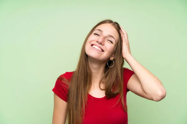 孤立した緑の壁の上に長い髪を持つ若い女性笑い — ストック写真