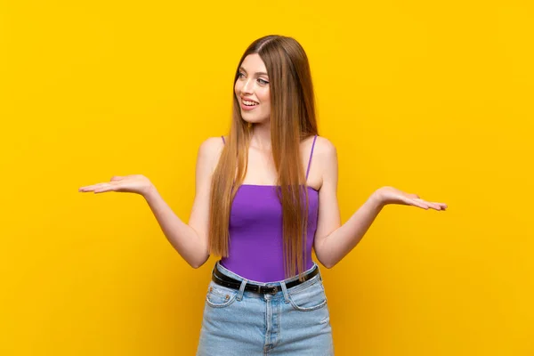 Young Woman Isolated Yellow Background Holding Copyspace Two Hands — Stock Photo, Image