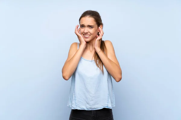 Jonge Vrouw Geïsoleerde Blauwe Achtergrond Gefrustreerd Het Bedekken Van Oren — Stockfoto