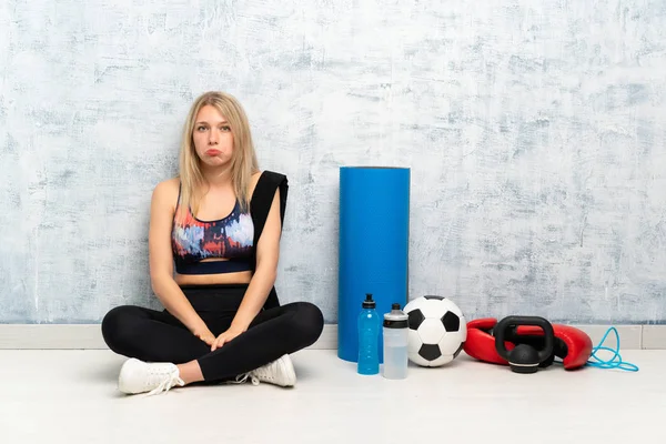 Νεαρή Ξανθιά Άθλημα Γυναίκα Κάθεται Στο Πάτωμα Λυπημένος — Φωτογραφία Αρχείου