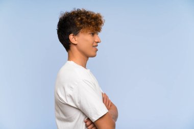 Beyaz gömlekli genç afro-amerikan adam ayakta ve yan bakıyor