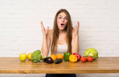 Sürpriz yüz ifadesi ile birçok sebze ile genç kadın