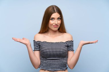 İzole mavi arka plan üzerinde genç kadın karıştırır yüz ifade ile şüpheler