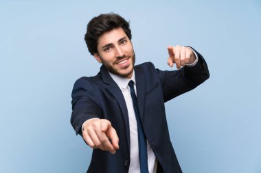 İzole mavi duvar üzerinde işadamı gülümserken parmak size parmak