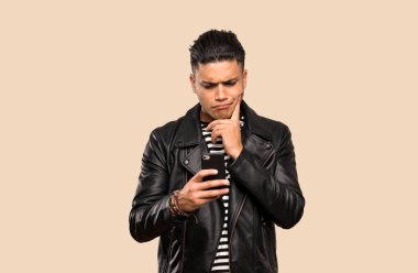 Genç adam düşünme ve izole arka plan üzerinden bir mesaj gönderme