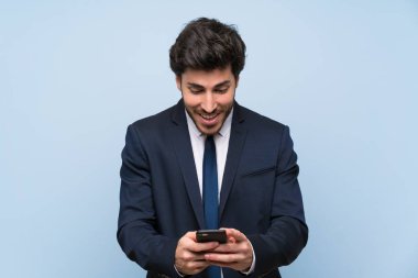 İzole mavi duvar üzerinde işadamı şaşırttı ve bir mesaj gönderme