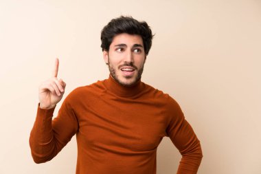 Bir parmak kaldırırken çözüm gerçekleştirmek niyetinde izole duvar üzerinde Yakışıklı