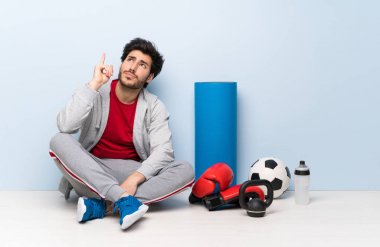 Spor adamı yerde oturmuş bir fikri düşünerek parmağınızı yukarı doğru işaret etti.
