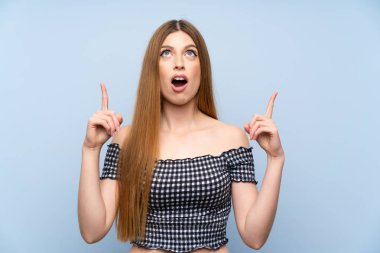 İzole edilmiş mavi arka planı olan genç bir kadın işaret parmağıyla işaret etmek harika bir fikir.