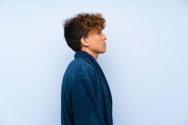 Pijama lı genç Afro-Amerikan adam kollarını çapraz tutmak ve yan bakıyor