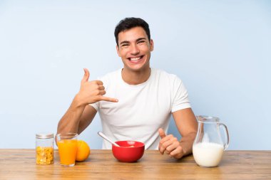 Telefon jesti yaparak kahvaltı yapan yakışıklı adam