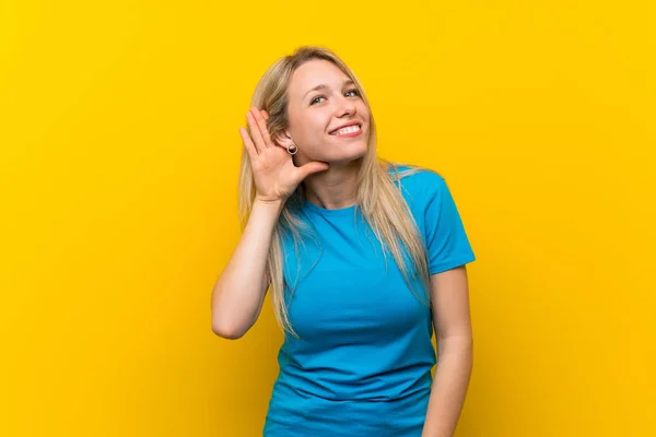 Jonge Blonde Vrouw Geïsoleerde Gele Achtergrond Luisteren Naar Iets Door — Stockfoto