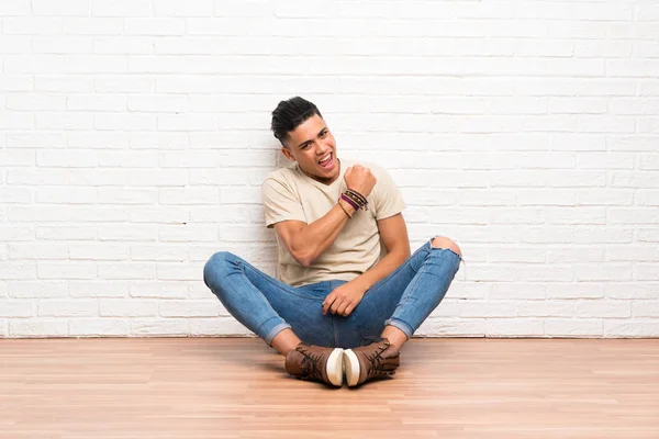 Jovem Sentado Chão Comemorando Uma Vitória — Fotografia de Stock