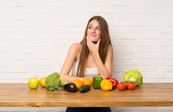 Young woman with many vegetables thinking an idea