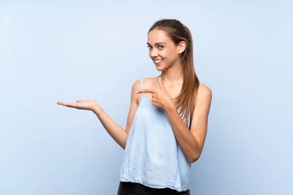 Mujer Joven Sobre Fondo Azul Aislado Sosteniendo Espacio Copia Imaginario — Foto de Stock