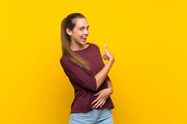 İzole edilmiş sarı arka planda genç bir kadın.