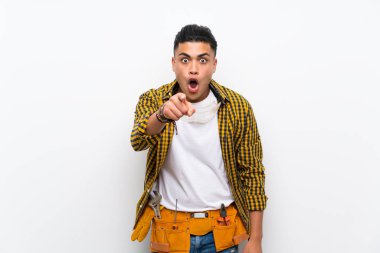 Izole beyaz duvar üzerinde genç elektrikçi adam şaşırttı ve ön işaret