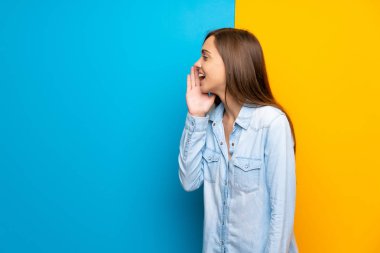 Renkli arka plan üzerinde genç kadın ağzı tamamen açık bağırıyor