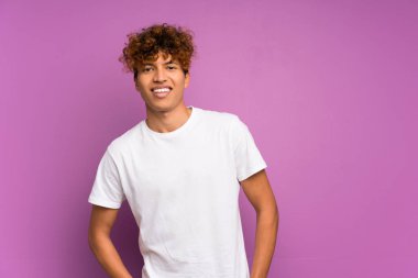 Izole mor duvar gülen üzerinde genç afrikalı Amerikalı adam