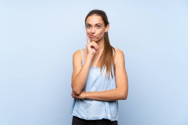 İzole mavi arka plan üzerinde genç kadın ön bakıyor