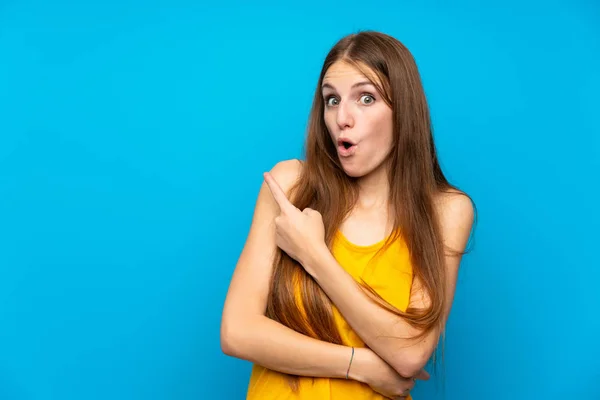 Jonge Vrouw Met Lang Haar Geïsoleerde Blauwe Muur Verrast Wijzend — Stockfoto