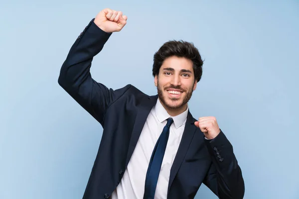 Zakenman Geïsoleerde Blauwe Muur Vieren Een Overwinning — Stockfoto