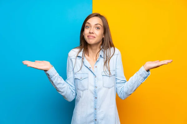 Mujer Joven Sobre Fondo Colorido Que Tiene Dudas Con Expresión —  Fotos de Stock